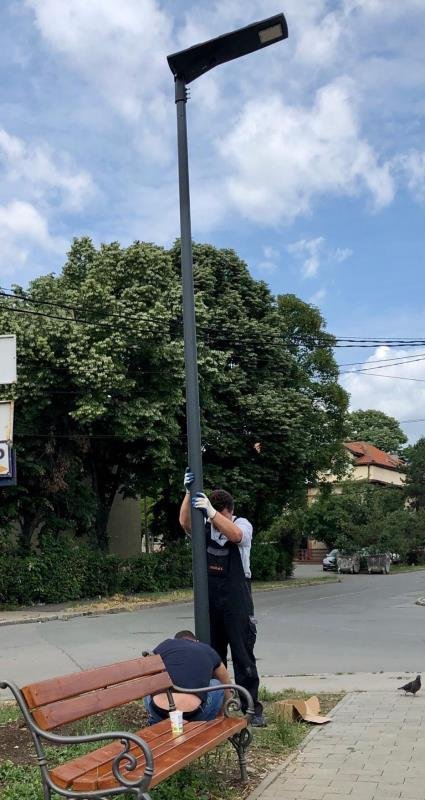 Workers installing solar street light pole in residential area