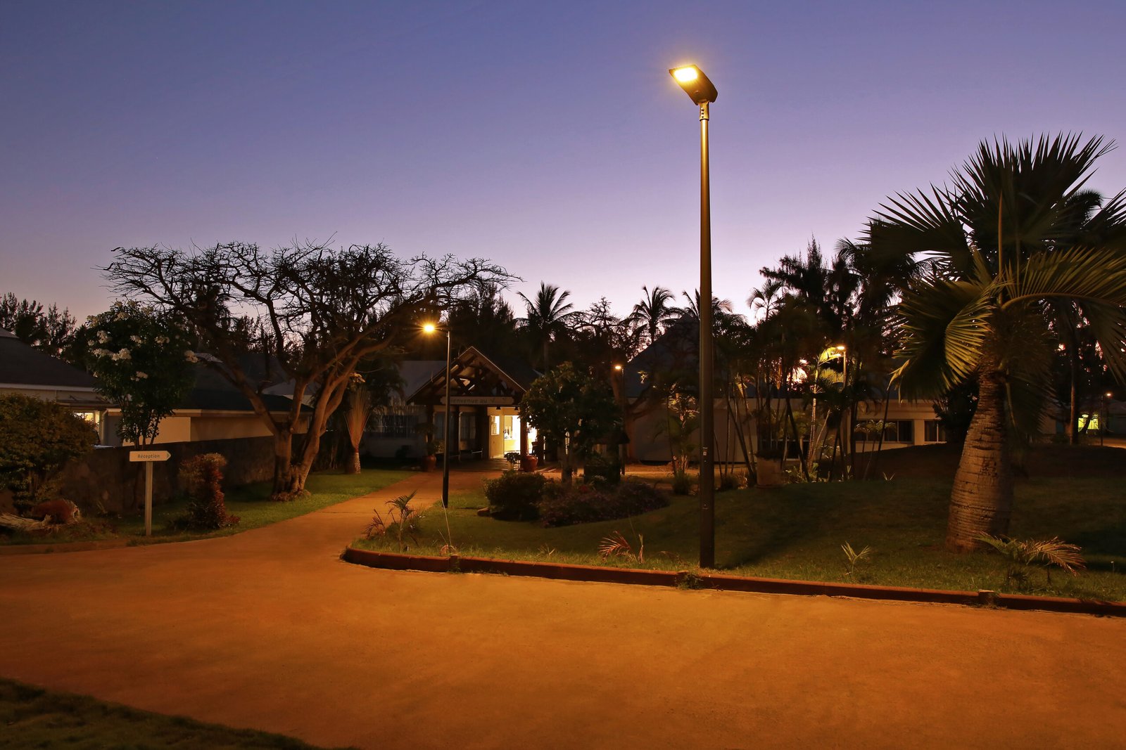 Scenic sunset view of a tropical resort path with solar lighting installation